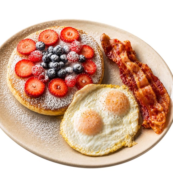 Berry pancake with two eggs and bacon